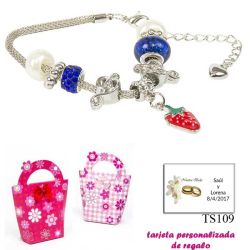 Pulsera con piedras blancas y azul electrico y un colgante de fresa