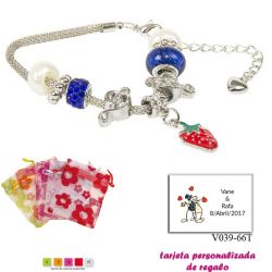Pulsera con piedras blancas y azul electrico y un colgante de fresa