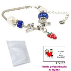 Pulsera con piedras blancas y azul electrico y un colgante de fresa